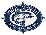 Logo of True North Seafood Company featuring a blue and white circular design. At the center, there is an illustration of a fish with the company’s name "True North Seafood Company" encircling it, along with a compass rose design in the background.